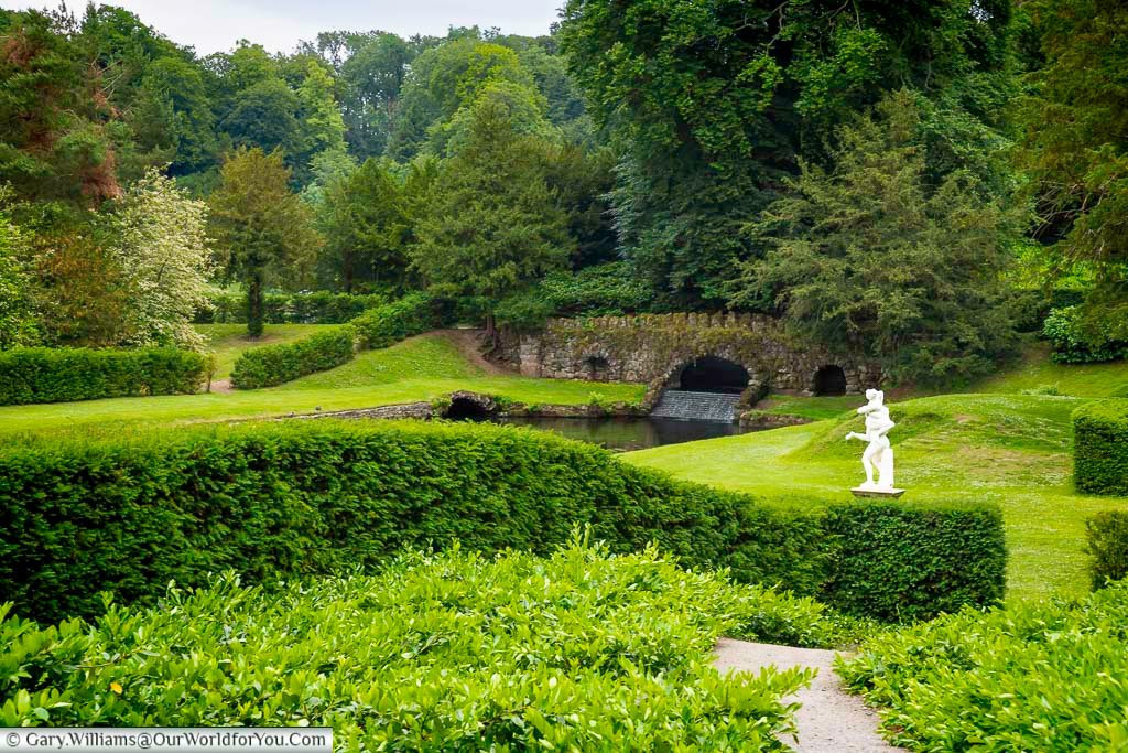 Lush green landscape at Studley Royal Water Garden in Yorkshire, with sweeping canals, curved ponds and the Temple of Piety framed by mature woodland. This peaceful National Trust garden near Fountains Abbey is one of the most beautiful hidden gems and historic places to visit in Yorkshire.