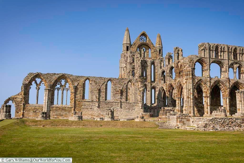 Whitby Abbey dominates the headland with its magnificent Gothic ruins, standing against a clear blue Yorkshire sky. One of England’s most iconic heritage sites, Whitby Abbey attracts visitors seeking medieval history, coastal views, and inspiration behind the Dracula legend.