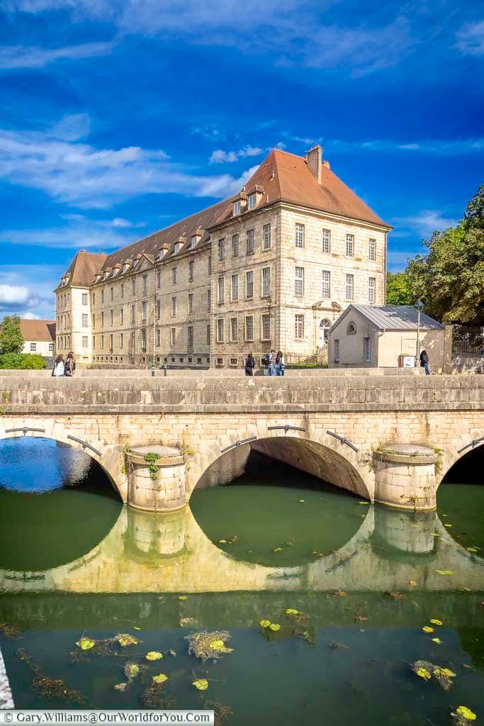 The former Charité General Hospital overlooks the River Doubs beyond the elegant arches of the Charles Nodier Bridge in Dole. This impressive historic building highlights the town’s architectural heritage and is one of the most recognisable sights in the Jura region.