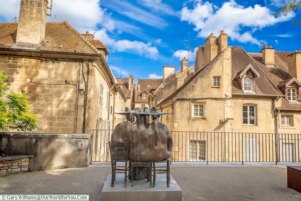 Seen from behind, the Les Commères sculpture overlooks the rooftops of historic Dole, creating a playful contrast between modern art and medieval architecture. This distinctive artwork is one of Dole’s hidden gems and a favourite photo opportunity for visitors exploring the Jura region.