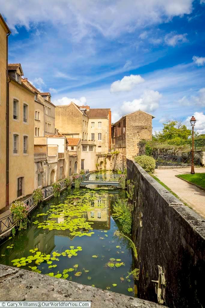 The peaceful Canal des Tanneurs winds through the historic centre of Dole, framed by charming stone buildings, flower displays, and tranquil waters filled with lily pads. This picturesque canal is one of Dole’s most scenic walking routes and a hidden gem to discover in France’s Jura region.