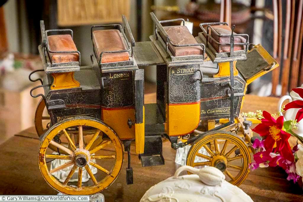 Detailed miniature horse-drawn carriage displayed inside Restoration House, reflecting the fascinating collection of historic and decorative objects found throughout the property.