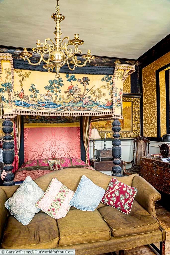 The magnificent King's Bed Chamber at Restoration House, with an elaborate four-poster bed, richly patterned fabrics, historic furnishings and decorative wall panels.
