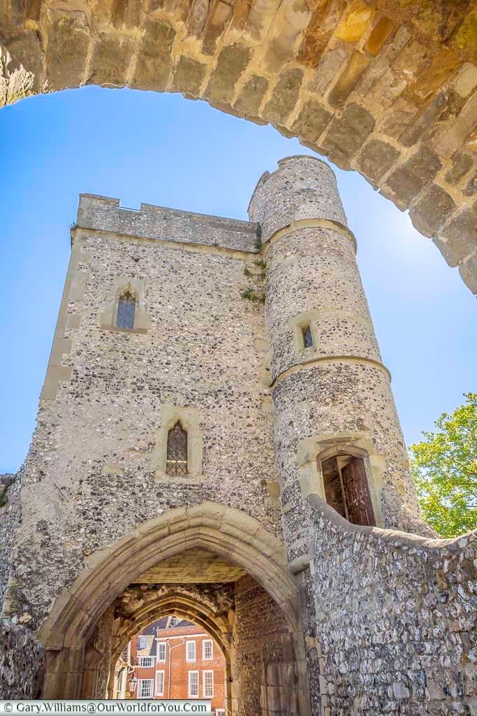 Looking upwards through the medieval gateway of Lewes Castle’s Barbican, revealing its impressive flint walls, arched entrance and rounded defensive tower.