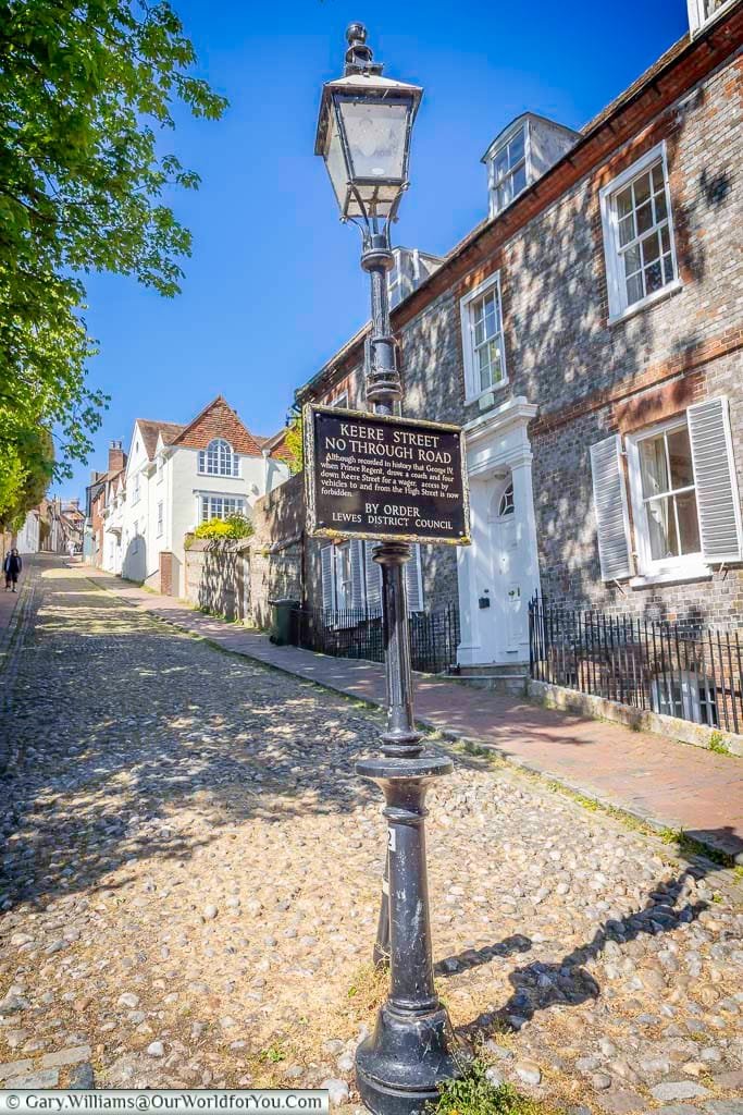The cobbled surface of historic Keere Street in Lewes, complete with its distinctive old lamp and sign warning that this steep lane is not a through road.