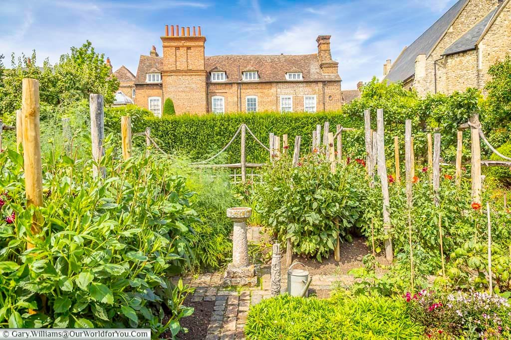 Colourful cutting garden at Restoration House in Rochester, with abundant flowers and traditional planting creating a beautiful view towards the historic brick house.