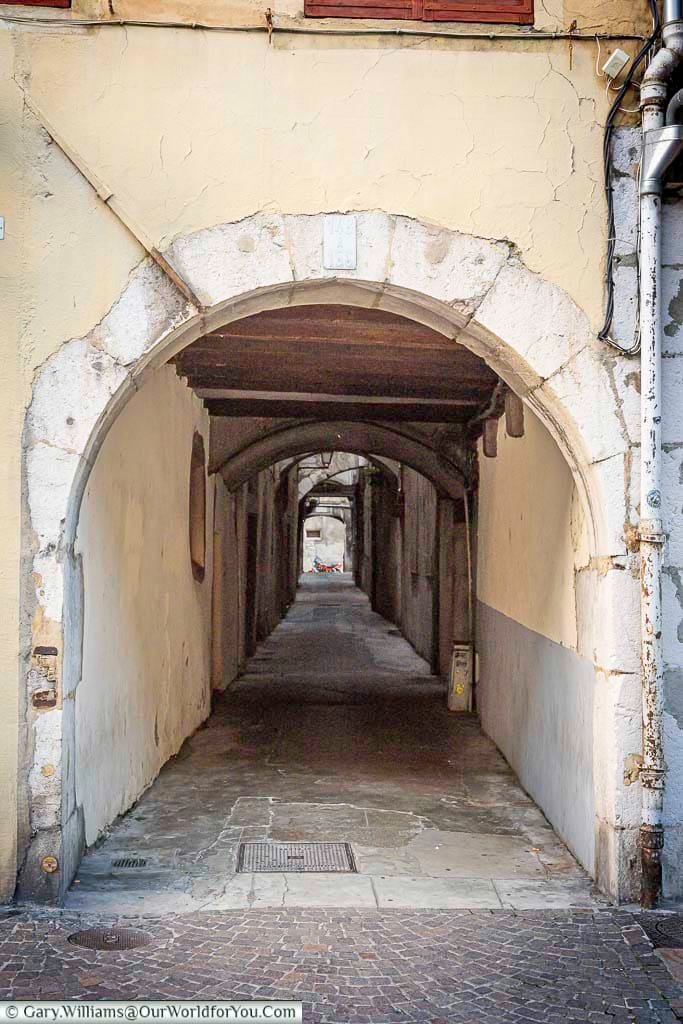 An old stone archway leads into one of Chambéry’s narrow covered passageways, a characteristic feature of the city’s historic centre. These atmospheric lanes and hidden alleys offer visitors a glimpse into the medieval layout of Chambéry, France.