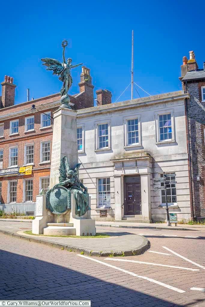 Lewes War Memorial standing prominently at the High Street crossroads, its bronze figures commemorating local people who lost their lives in conflict.
