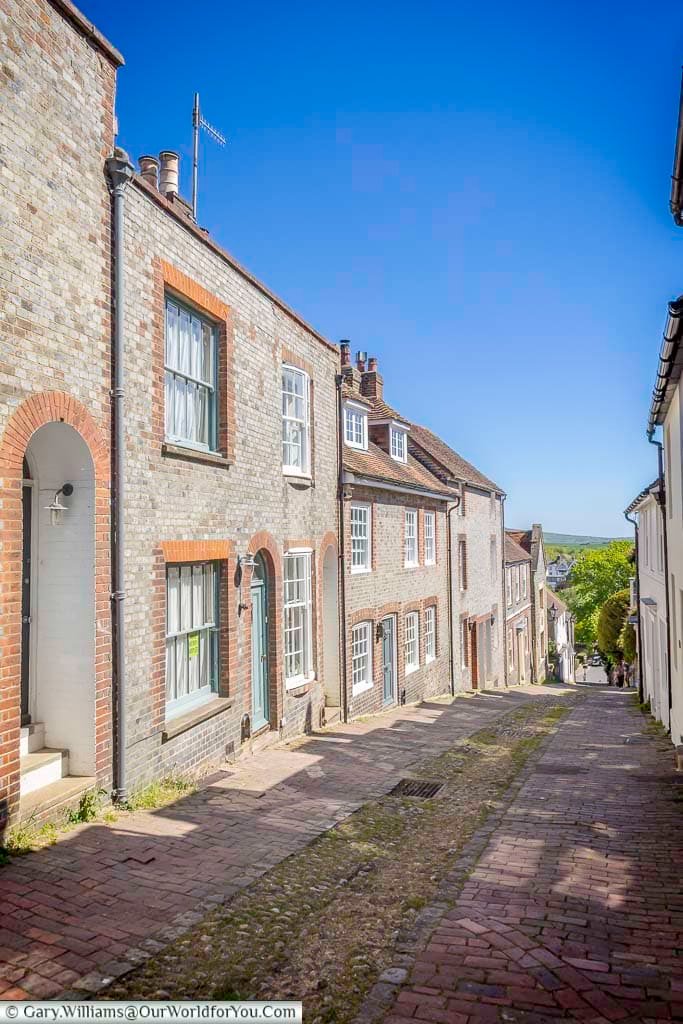 Looking down historic Keere Street in Lewes, where old brick houses and a steep cobbled lane descend towards the lower part of this characterful Sussex town.