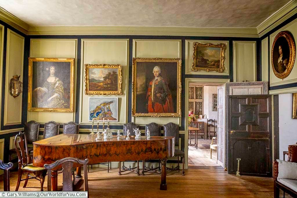 The elegant Great Chamber at Restoration House in Rochester, displaying historic portraits, antique furniture and one of the room's two distinctive period pianos.