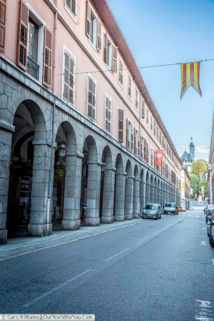Rue de Boigne in Chambéry is lined by an impressive sequence of stone arcades and elegant historic buildings decorated with colourful banners. The grand street is one of the most recognisable sights in Chambéry and a highlight of any walking tour through the city centre.