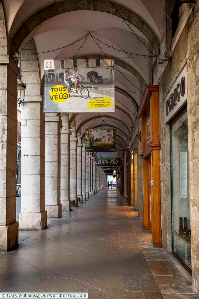 The elegant stone colonnade of Rue de Boigne stretches through the historic centre of Chambéry, lined with shops beneath its vaulted arcades. This distinctive covered walkway is one of the architectural highlights to discover on a Chambéry walking tour.
