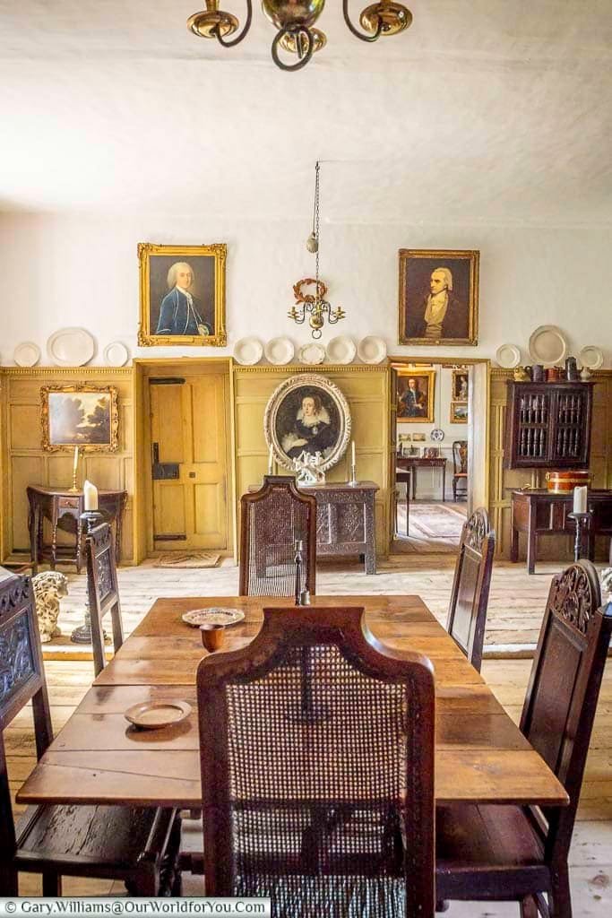 The Great Hall at Restoration House in Rochester, with a long wooden dining table, carved chairs, historic portraits and an impressive collection of period furnishings.
