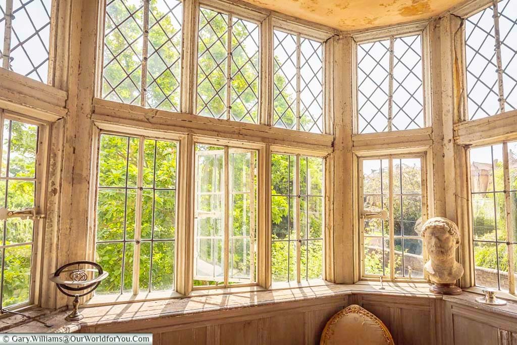 Sunlight streams through the magnificent leaded-glass oriel window at Restoration House in Rochester, illuminating historic woodwork and views into the gardens.