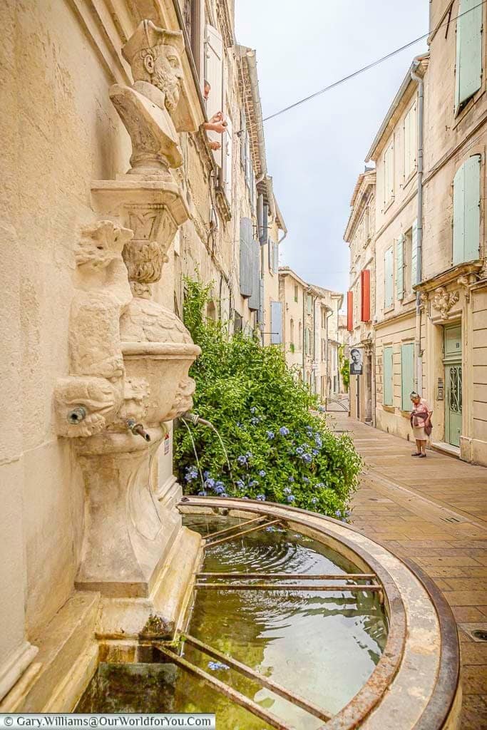 Historic Fontaine Nostradamus beside a narrow old-town street in the centre of Saint-Rémy-de-Provence, Provence, France.