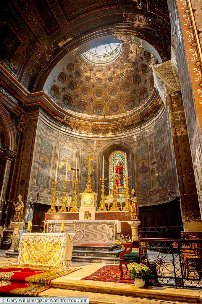 Ornate altar, painted dome and stained-glass window inside the historic Collégiale Saint-Martin in Saint-Rémy-de-Provence.