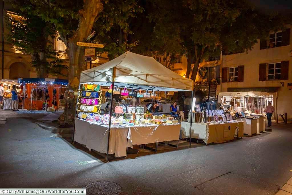 Evening craft stalls beneath the plane trees at the Marché Nocturne des Créateurs in Saint-Rémy-de-Provence, Provence.