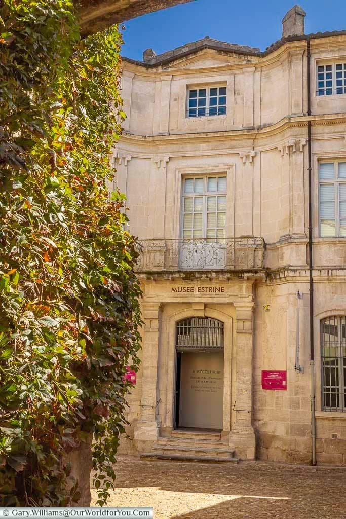 Historic stone façade and entrance to Musée Estrine, an art museum in the centre of Saint-Rémy-de-Provence, Provence, France.