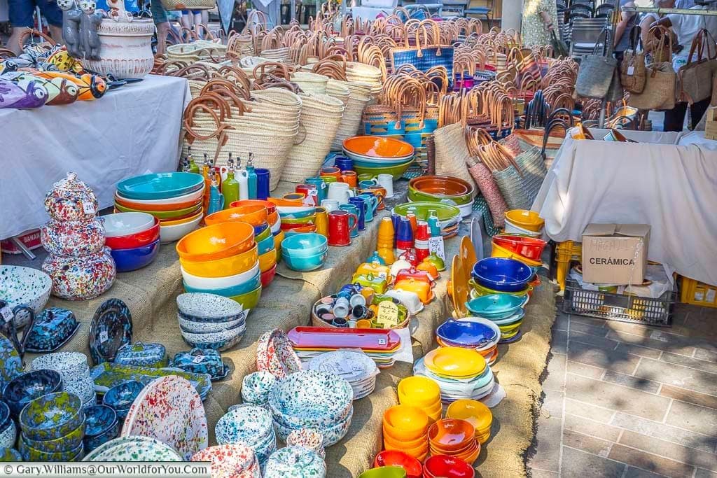 Colourful handmade pottery, bowls and traditional woven shopping baskets for sale at the Saint-Rémy-de-Provence market in Provence.