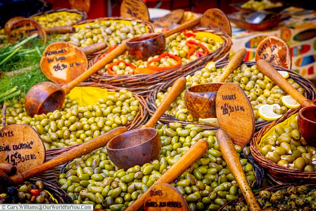 Baskets overflowing with green olives, herbs, peppers and lemons at the traditional market in Saint-Rémy-de-Provence, Provence.