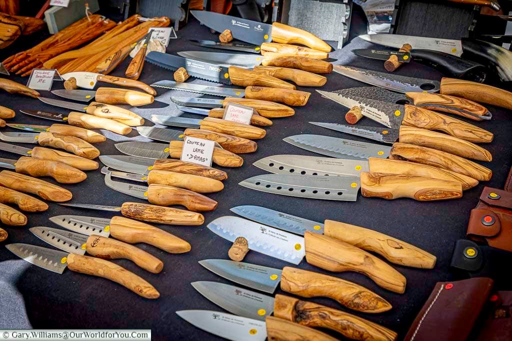 Handcrafted knives with polished olive wood handles displayed at the traditional market in Saint-Rémy-de-Provence, showcasing Provençal craftsmanship.