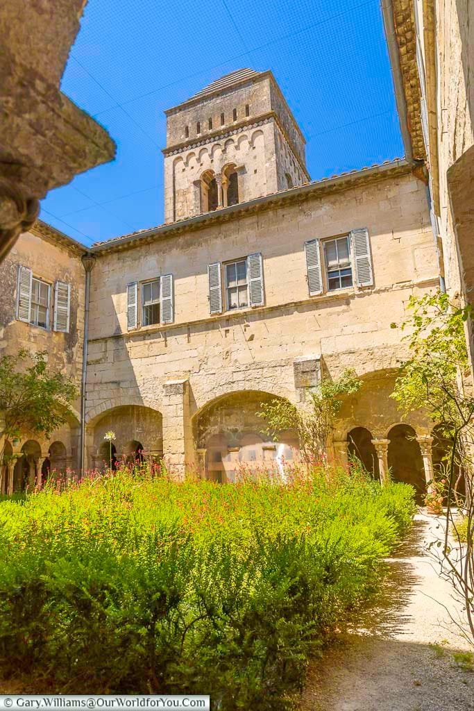 Peaceful cloister garden and Romanesque bell tower at Saint-Paul-de-Mausole in Saint-Rémy-de-Provence, southern France.