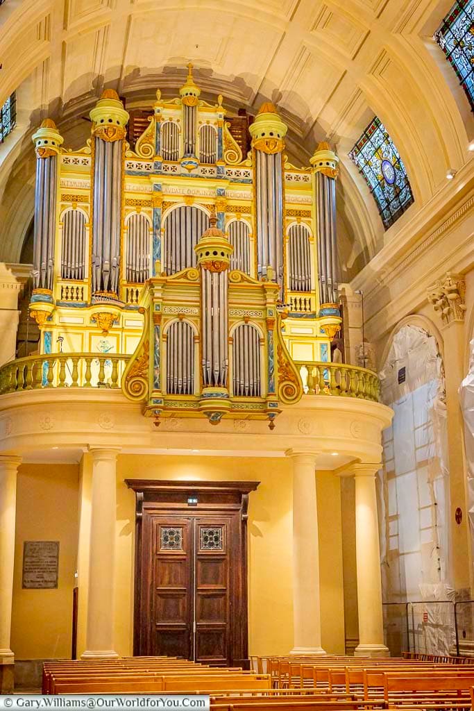Impressive historic pipe organ and stained-glass windows inside the Collégiale Saint-Martin in Saint-Rémy-de-Provence, France.