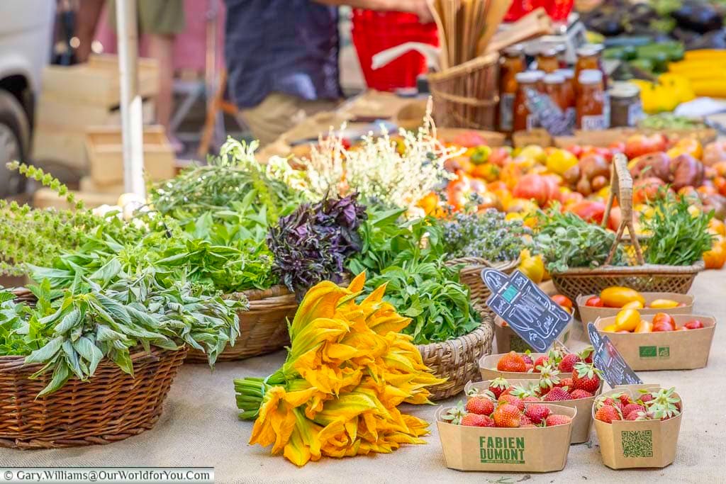 Colourful fresh strawberries, tomatoes, herbs and courgette flowers for sale at the vibrant market in Saint-Rémy-de-Provence, Provence.