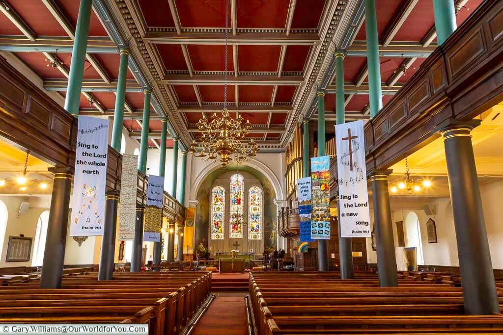 The beautiful interior of St Andrew’s Church in Penrith features wooden pews, elegant columns, ornate chandeliers and colourful stained-glass windows. This historic Cumbrian church combines impressive architecture with a peaceful and welcoming atmosphere.
