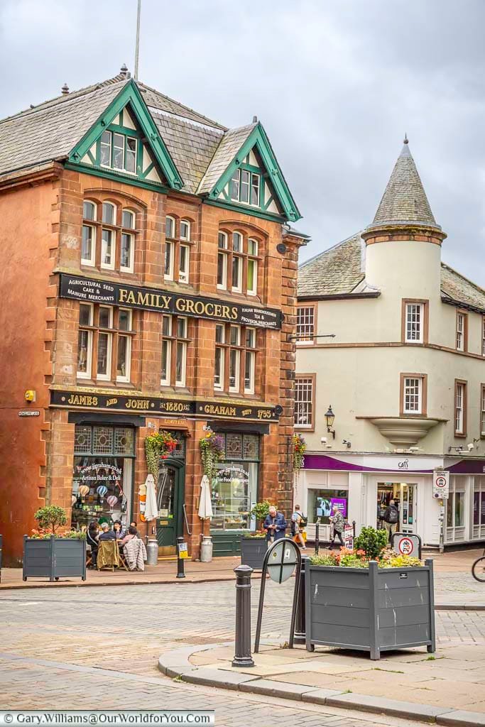 The traditional sandstone frontage of James and John Graham Family Grocers stands proudly in Penrith town centre, with decorative green gables and historic signage. This characterful building reflects the town’s long-established independent shopping heritage.