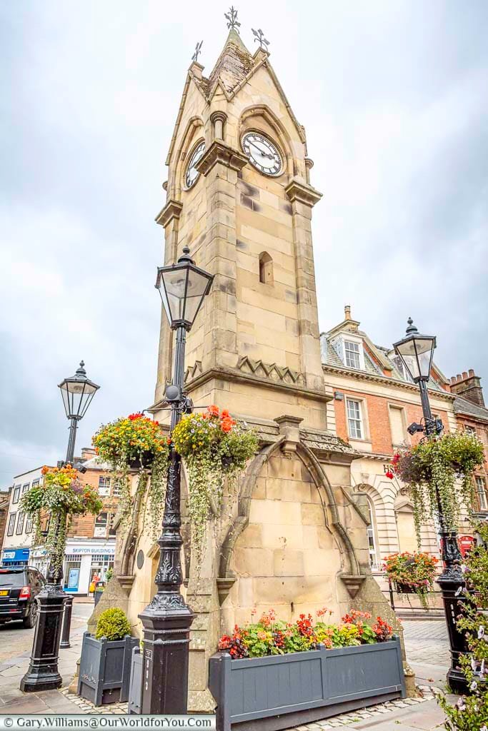 The impressive Gothic-style Musgrave Monument rises above Penrith’s Market Square, surrounded by traditional streetlamps and colourful floral displays. This distinctive Victorian clock tower is one of the most recognisable landmarks in the historic Cumbrian town.